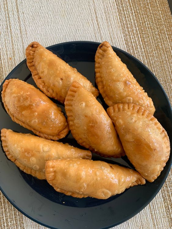 Step 6.1: Remove the gujiyas from the syrup and arrange them on a plate to cool down