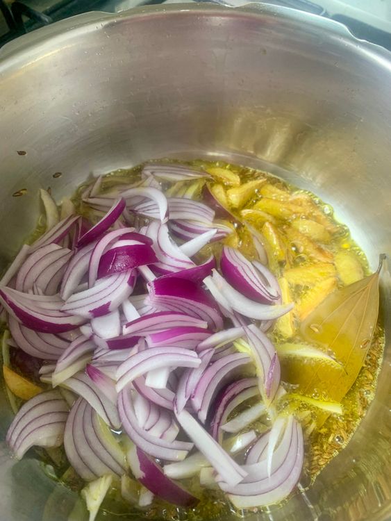 Step 3.1: Add sliced garlic, sauté until golden, then add onions and cook until soft and translucent