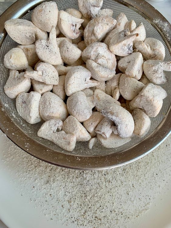 Step 5.1: Shake off excess flour and fry the mushrooms in small batches for 1–2 minutes until lightly golden