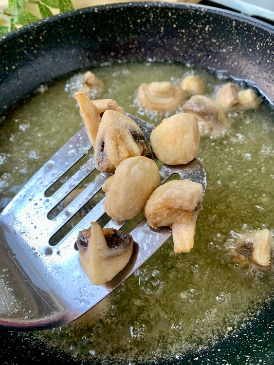Step 5.2: Shake off excess flour and fry the mushrooms in small batches for 1–2 minutes until lightly golden