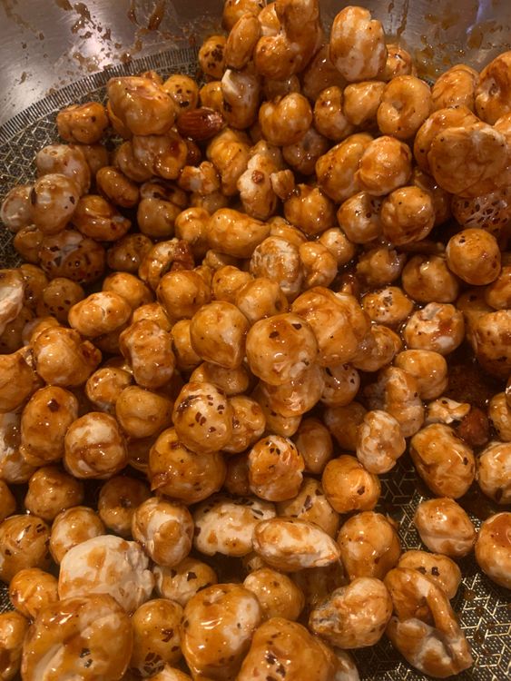 Step 2.1: Add the roasted makhana and almonds to the pan, tossing them in the jaggery mixture until they are evenly coated