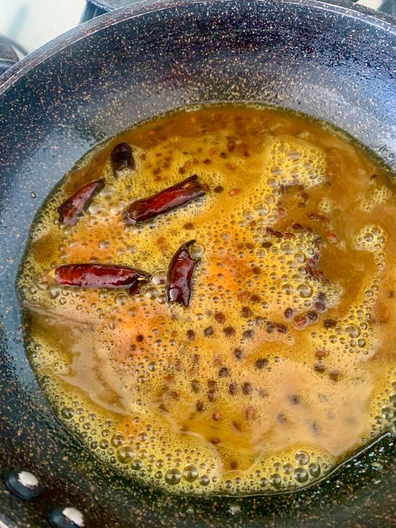 Step 4.1: Turn off the heat, add turmeric powder, stir and immediately pour the hot tempering over the cucumber-potato mixture