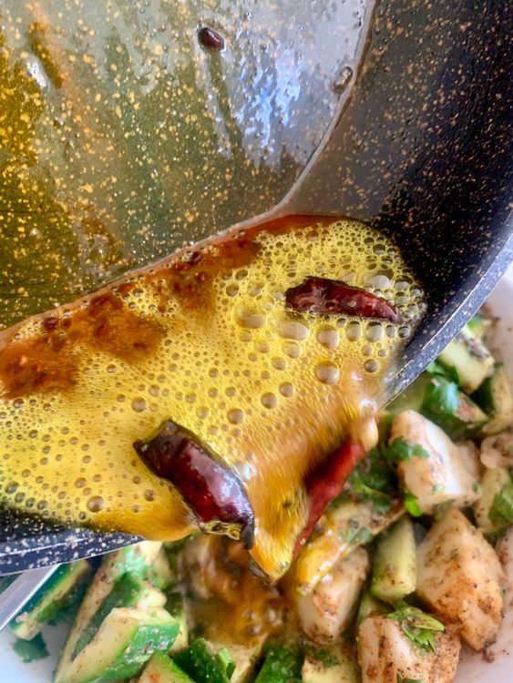 Step 4.2: Turn off the heat, add turmeric powder, stir and immediately pour the hot tempering over the cucumber-potato mixture