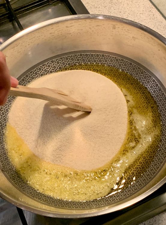 Step 1.1: Once the ghee is hot, add the suji to the pan and stir continuously