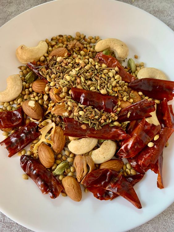 Step 2.2: Dry roast mace, cloves, green cardamom, nutmeg, dry red chillies, coriander seeds, fennel seeds, cumin seeds, almonds, and cashews on low to medium heat for 2-3 minutes, until fragrant