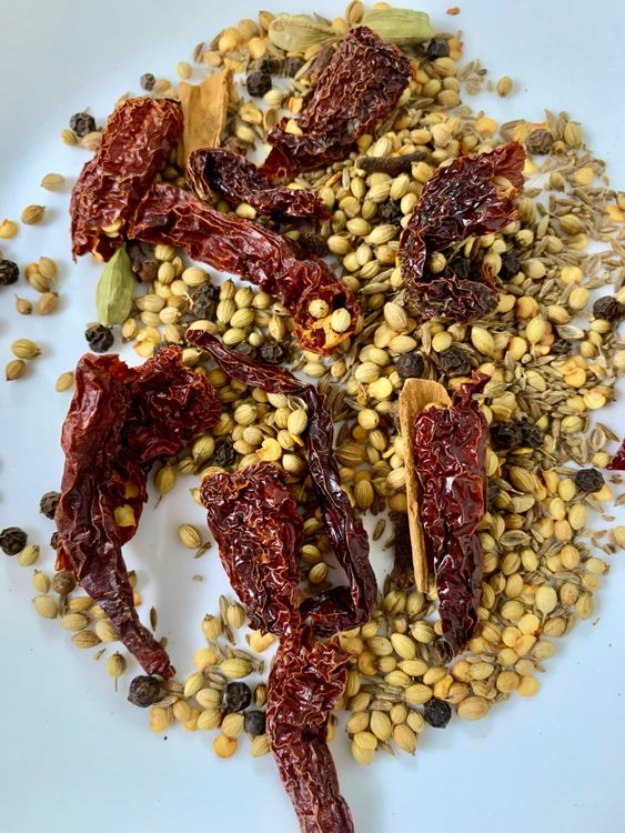 Step 2.2: Dry roast coriander seeds, cumin seeds, peppercorns, ajwain, cinnamon, cardamoms, cloves, and whole red chillies on low-medium heat for 2–3 minutes until aromatic