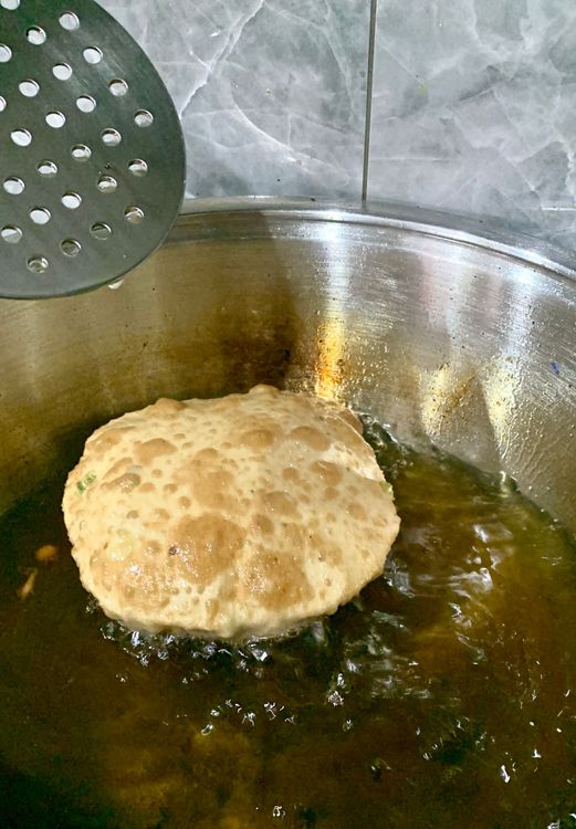 Step 1.1: Turn the poori when puffed up and fry till golden brown and crispy from both sides