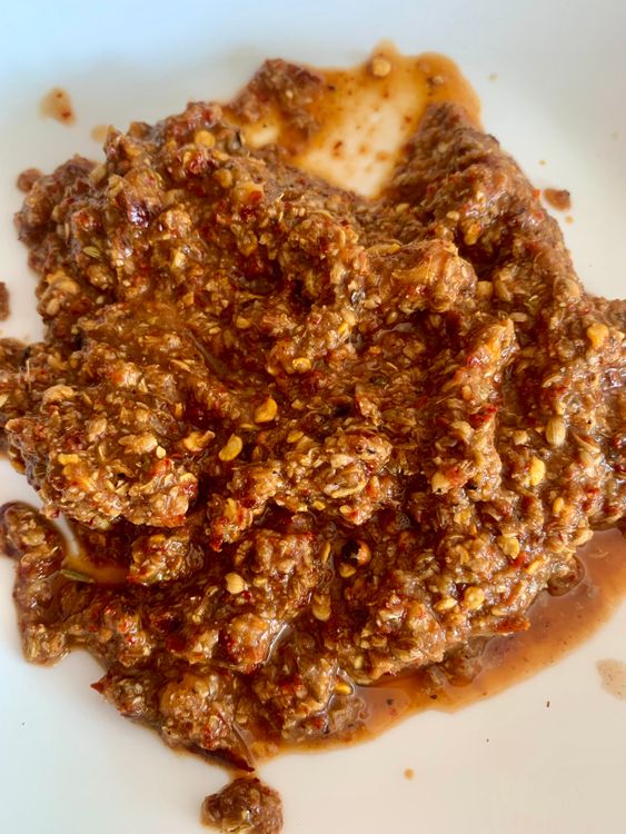 Step 2.2: Grind the roasted spices with garlic and tamarind pulp to form a paste, adding very little water