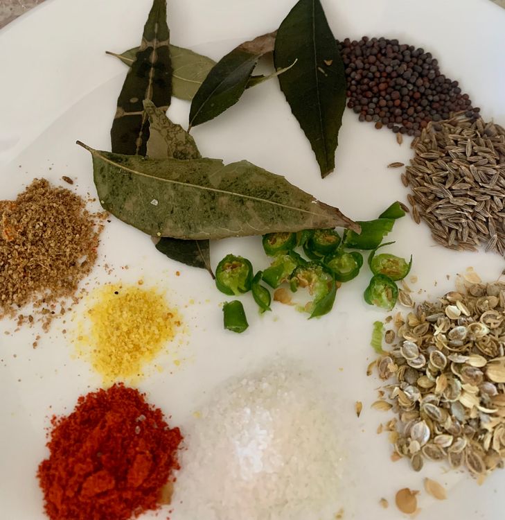 Step 1.1: Keep the spices (asafoetida, cumin seeds, coriander seeds, mustard seed, red chilli powder, chopped green chillies, turmeric powder, curry leaves, dried pomogranate seeds, dried coriander seeds, and garam masala) in a plate, ready for tempering