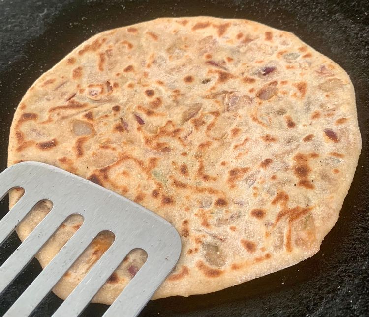 Step 2.1: Brush the paratha with a little oil and flip it again and press gently with a flat ladle