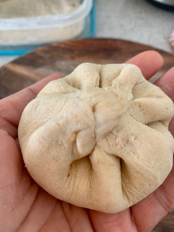 Step 2.2: Place a portion of prepared stuffing and seal all sides of the dough together to form a ball