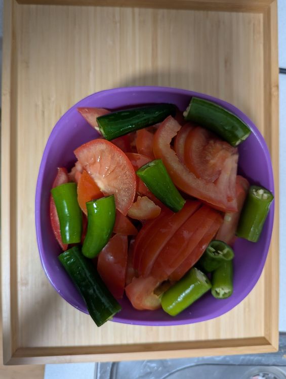 Step 1.1: While the meat fries, cut all the tomatoes into 4 pieces and chop the ends off all the green chilies