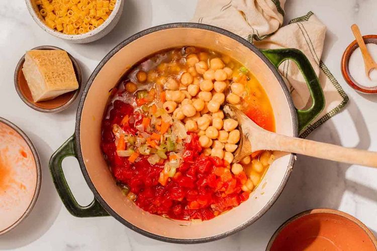 Step 3.1: Stir in tomato passata and chickpeas, plus a ladleful of water, broth, or chickpea cooking liquid