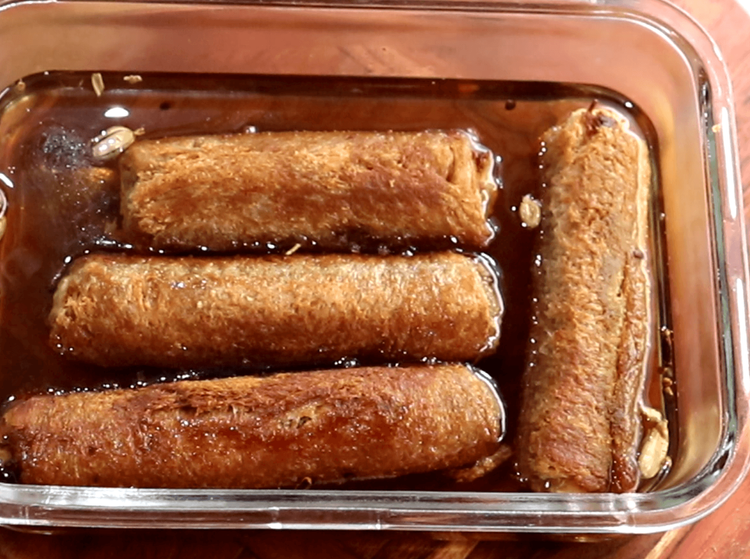 Step 5.1: While still warm, dip the fried rolls into the sugar syrup for 4-5 minutes, allowing them to absorb the syrup
