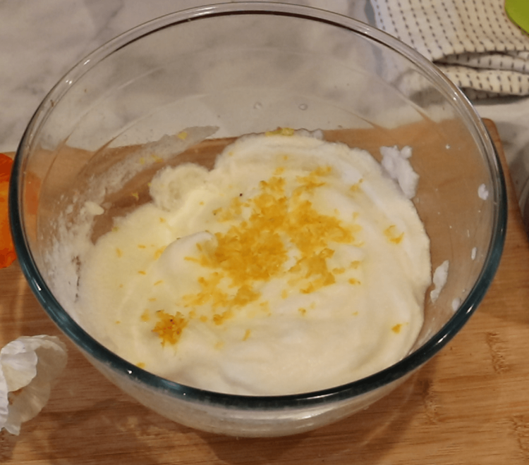 Step 1.1: Add the lemon zest to the bowl and gradually fold the almond-sugar mixture into the whisked egg white, gently combining with a spatula to form a dough
