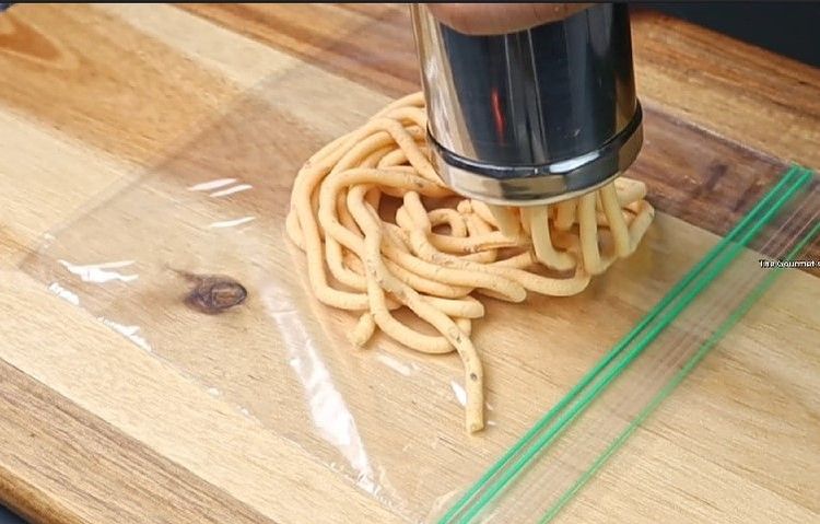 Step 3.4: Press the dough into spiral shapes (traditional murukku shapes) on a greased plate or [parchment paper](https://amzn