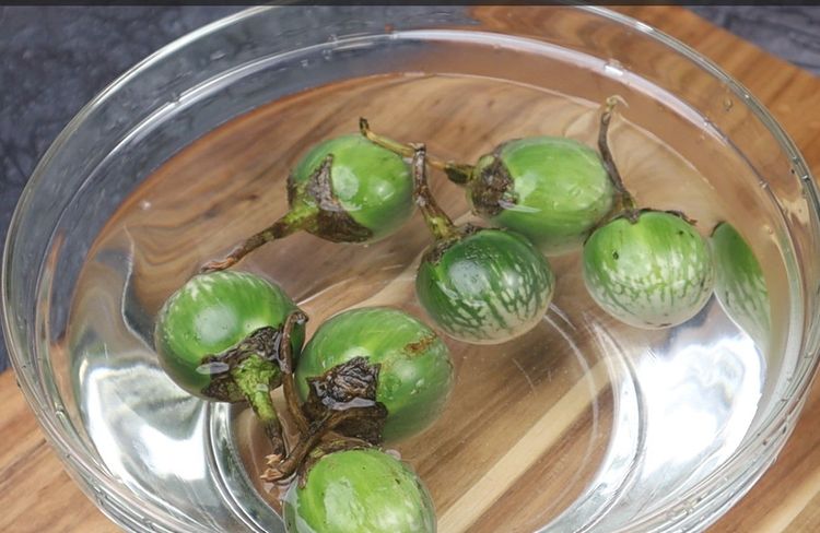 Step 1.1: Cut each brinjal in an 'X' shape without separating the pieces completely