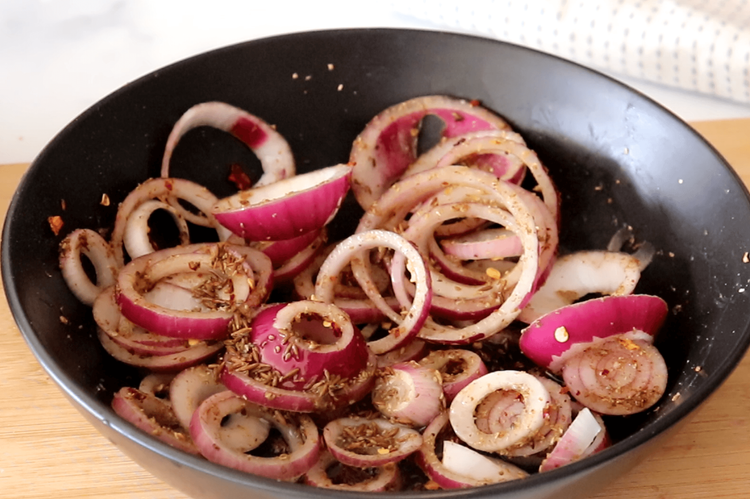 Step 3.1: Pour the hot tempering over the onion mixture and toss well