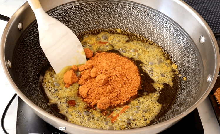 Step 4.1: Add jaggery to the pan and stir continuously until it melts completely