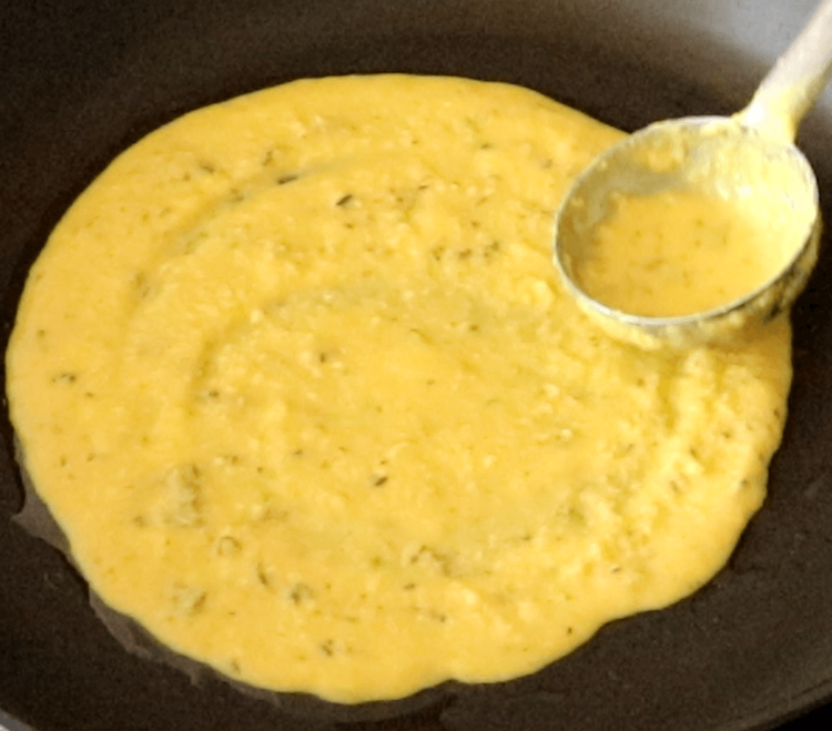 Step 1.1: Pour a ladleful of batter into the center of the pan and spread it in a circular motion using the back of the ladle to form a thin, round chilla