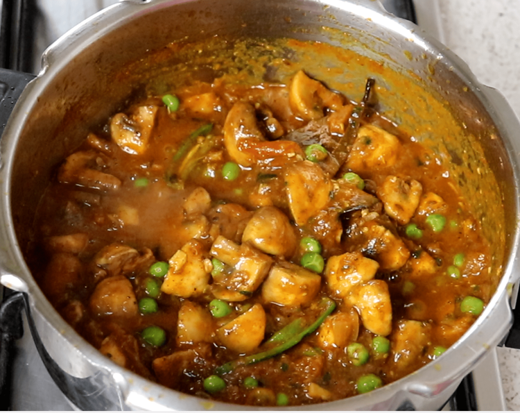Step 5.2: Now add the sautéed mushrooms, mix gently, and pressure cook again for 2–3 whistles