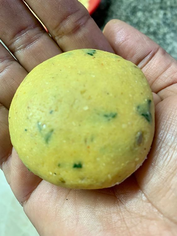 Step 2.1: Take a dough ball, dust it with a bit of cornmeal flour and place it on the rolling board