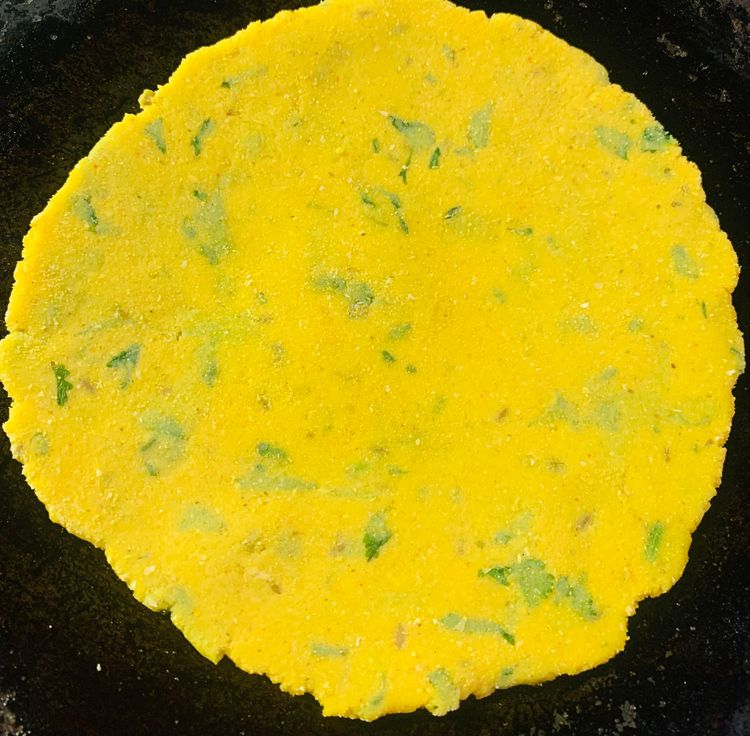 Step 2.1: Drizzle little oil on the tawa/skillet and place the cornmeal roti on it