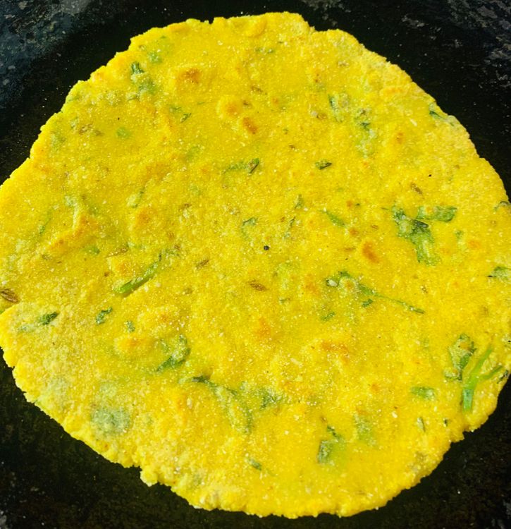 Step 2.2: Drizzle little oil on the tawa/skillet and place the cornmeal roti on it