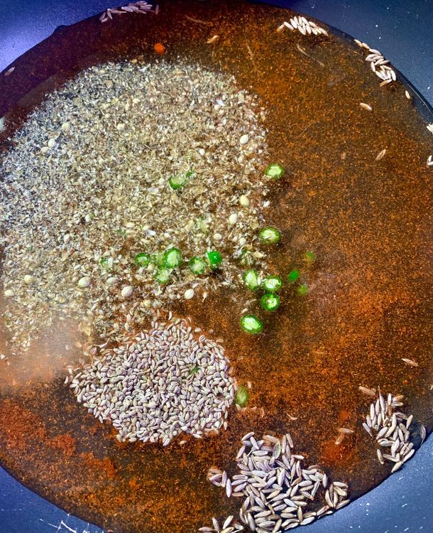 Step 1.1: Add water, salt, carom seeds, red chilli powder, cumin seeds, coriander powder and, green chilli in a deep skillet