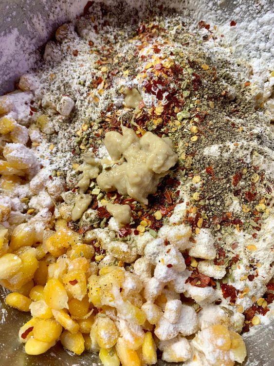 Step 1.1: In a large bowl, mix together corn kernels, all-purpose flour (maida), cornflour, white pepper, chilli flakes, black pepper powder, oregano, salt, and ginger garlic paste, and mix nicely