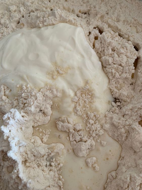 Step 2.1: Add curd and milk to the flour and mix with light hands