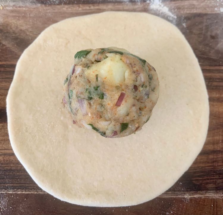 Step 3.2: Place a portion of the prepared stuffing and seal all sides of the dough together to form a ball