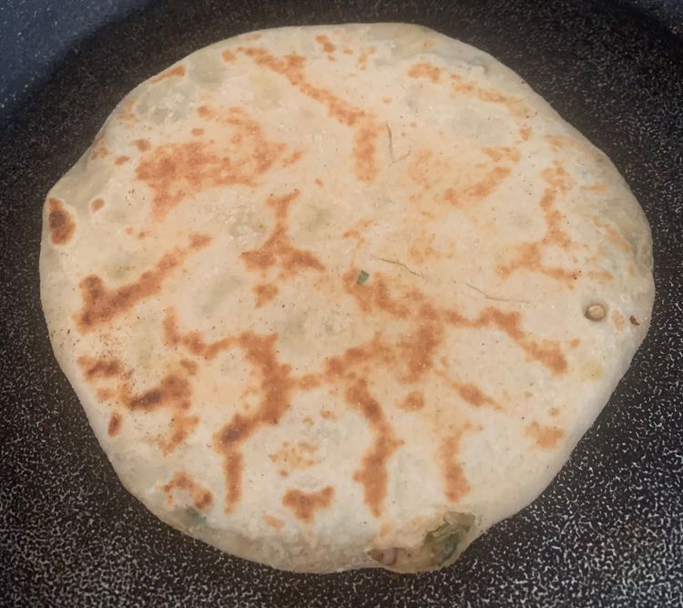 Step 4.1: Drizzle little water on the skillet, place the stuffed naan, and cook for 3-4 minutes