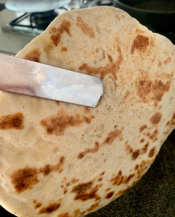 Step 4.2: Hold the naan with a tong