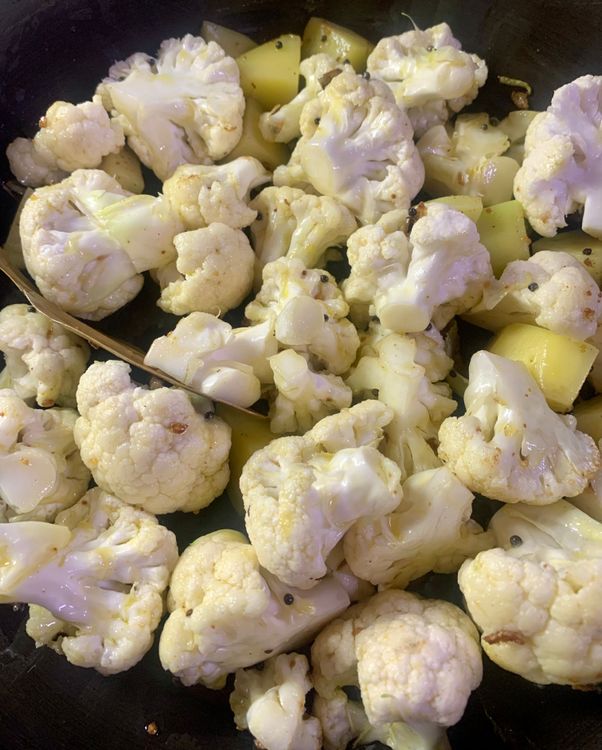 Step 3.1: Add the cauliflower florets and potatoes to the pan