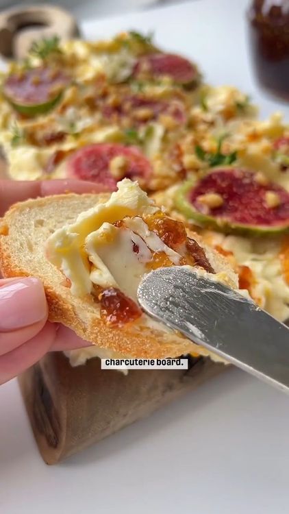 Step 1.1: Arrange the assorted breads, crackers, fruits, and vegetables around the butter on the board