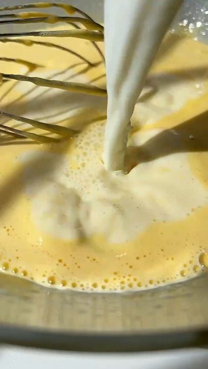 Step 1.1: Gradually add the warm milk into the egg yolk mixture, whisking continuously