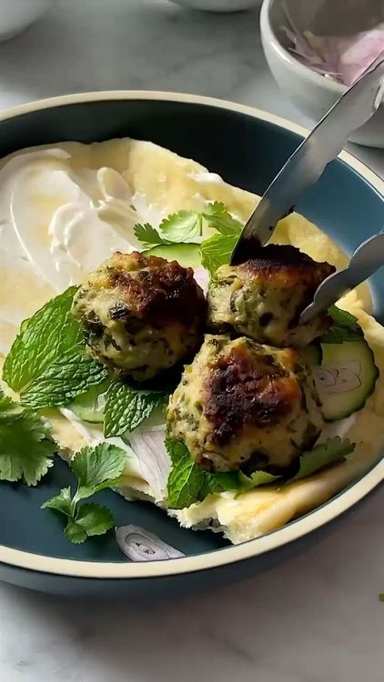 Step 3.1: Serve the meatballs on naan with sliced cucumber, fresh herbs, and a sprinkle of chili flakes