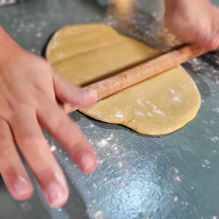 Step 3.2: Get a rolling pin ready, lightly dust the counter with flour, place your dough onto the floured surface, and press flat