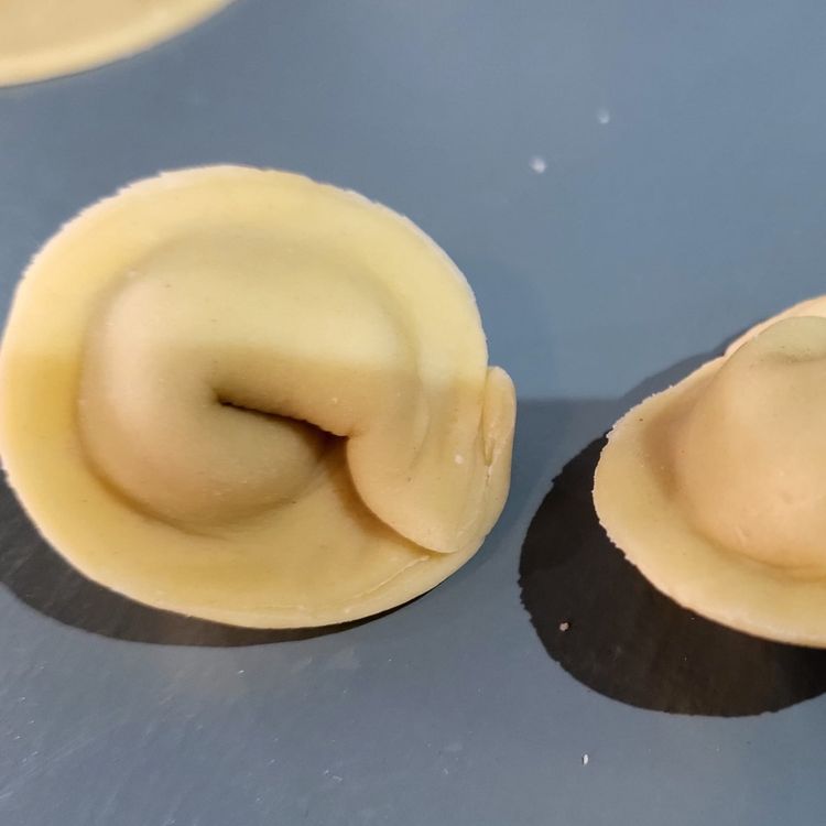 Step 3.1: Take the two points of each half-moon and gently bring them together, letting them overlap and pinch to seal the two points