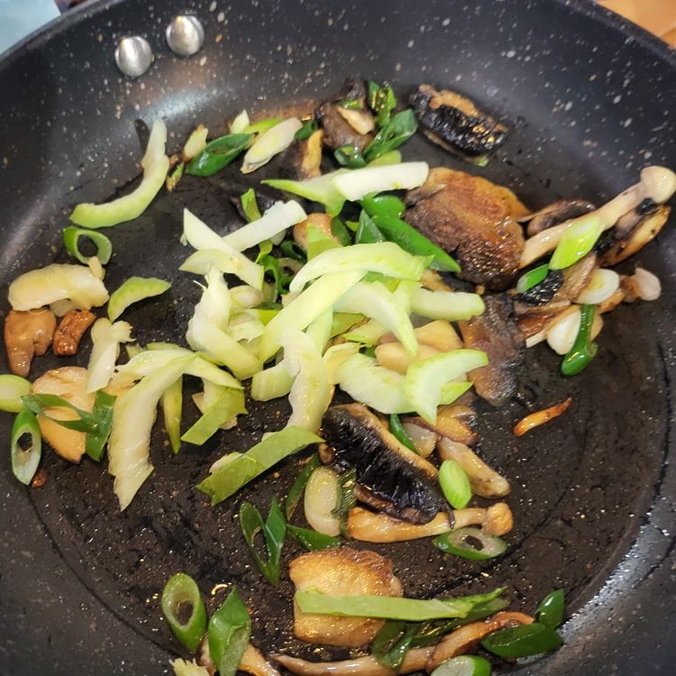 Step 2.1: Add half of the spring onions, then place the noodles on top