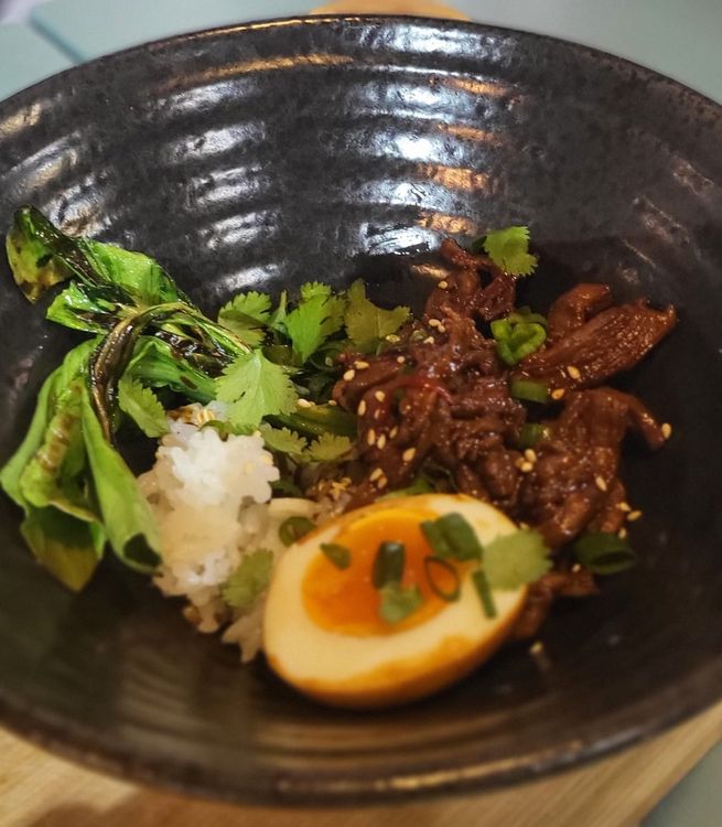 Step 1.1: Prepare your bowls by starting with the sushi rice, then beef on the side, pak choi, and egg