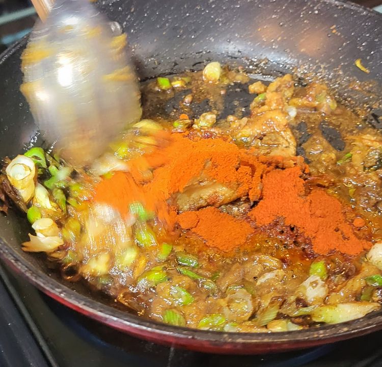 Step 1.2: Heat a wok to medium heat, add the last bit of vegetable oil, then add half of the spring onions