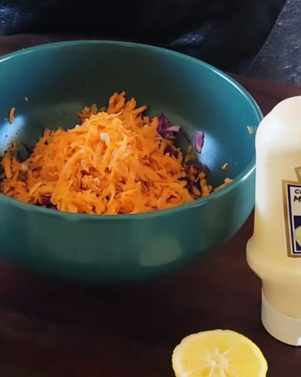 Step 5.1: In a large bowl, combine finely sliced red cabbage and grated carrots