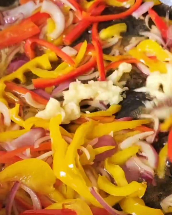 Step 2.1: Toss in the sliced red and yellow capsicums and stir fry for 2-3 minutes, allowing them to soften slightly but retain their crunch