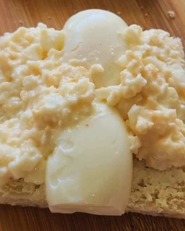 Step 1.1: Place the sliced egg first then spread the egg mixture evenly across one slice of white milk bread