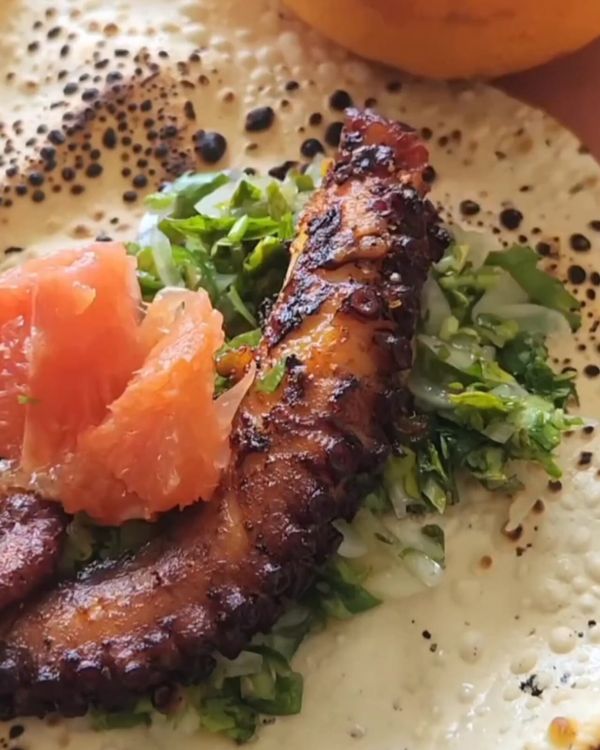 Step 2.1: Place each piece of air-fried octopus on a crispy papad, drizzle with gremolata, and serve with a slice of broiled, salted grapefruit on the side