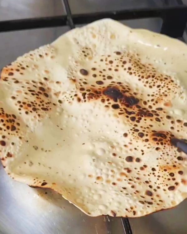 Step 2.1: Lightly brush the papad with ghee and cook it over an open gas flame, flipping frequently until crispy and slightly charred