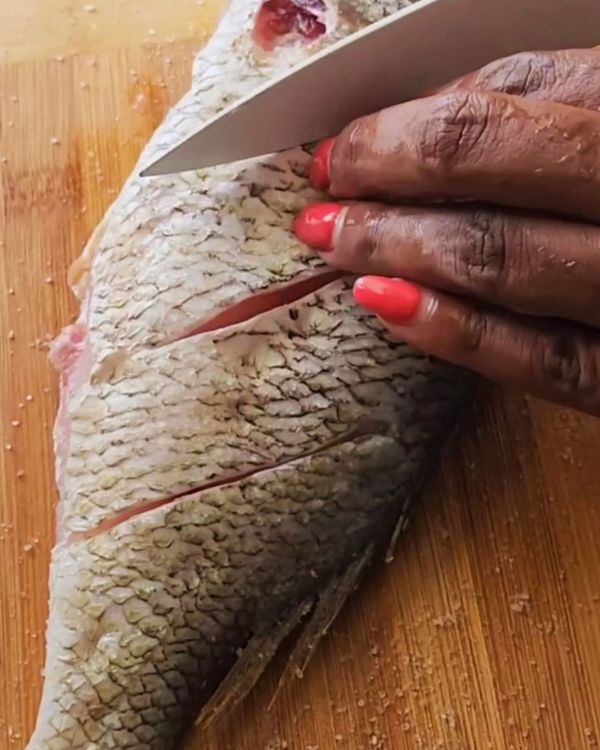 Step 1.1: Using a sharp knife, make diagonal cuts on both sides of the snapper, about 1 inch apart
