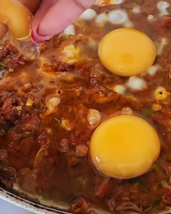 Step 3.1: Use a spatula to create small pockets in the sauce, and carefully break an egg into each pocket